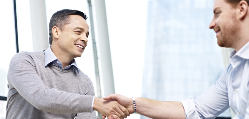 caucasian businesspeople shaking hands in office