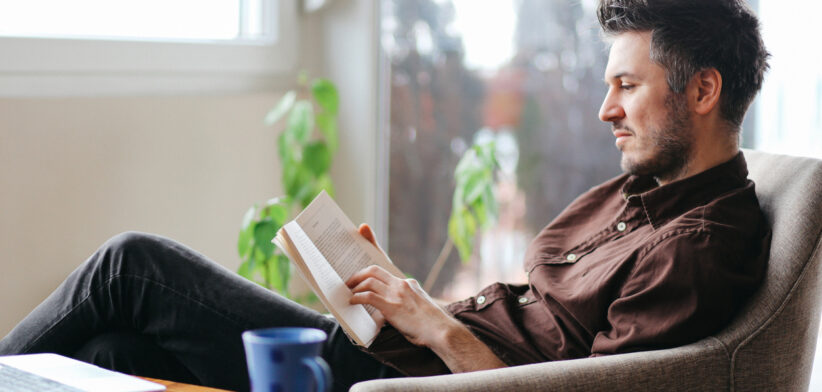 Young man reading a book at home