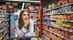 Woman buy products with her trolley at supermarket.