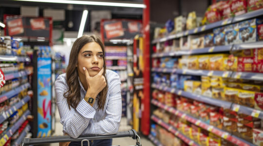 Woman buy products with her trolley at supermarket.