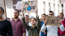 People with placards and protective suit on global strike for climate change.