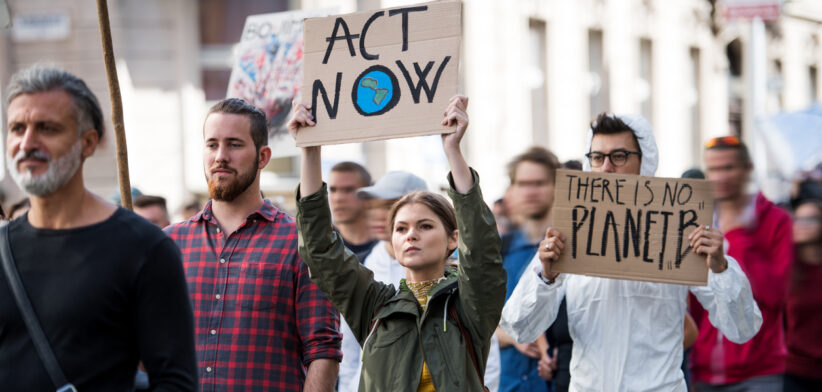 People with placards and protective suit on global strike for climate change.
