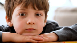 Bored pensive little boy looking at the camera