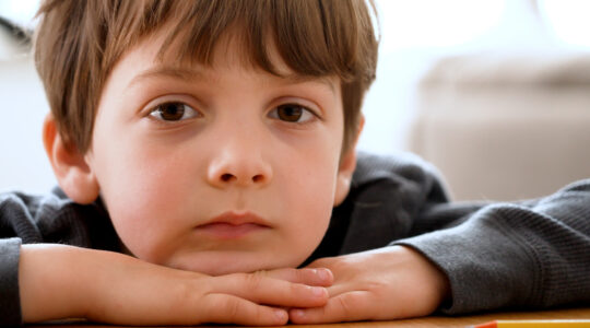 Bored pensive little boy looking at the camera