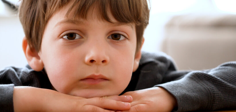 Bored pensive little boy looking at the camera