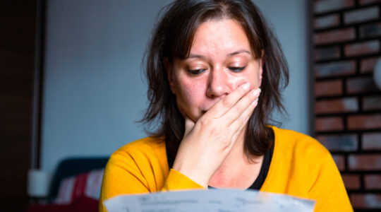 Worried woman checking bills at home