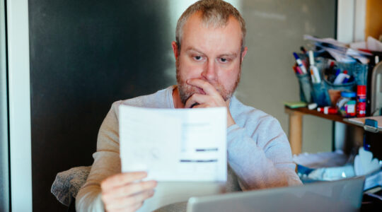 Worried man checking bills at home