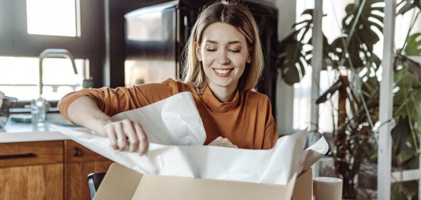 Satisfied young woman opening a postal delivery