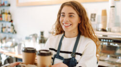 Female barista making coffee in coffee shop counter. Takeaway food.