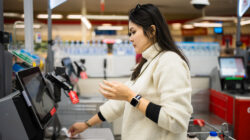Female checkout by automatic payment machine in supermarket – Newsreel