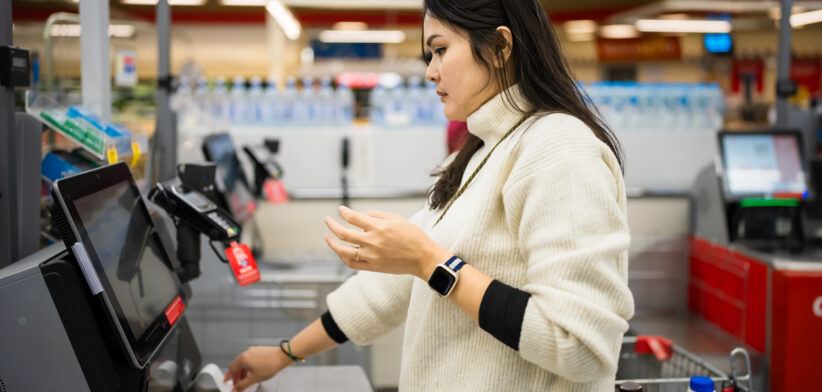 Female checkout by automatic payment machine in supermarket – Newsreel