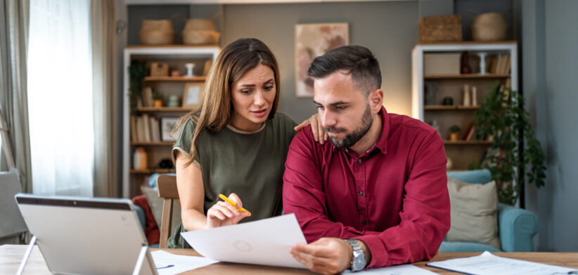 Worried young couple manages home finances