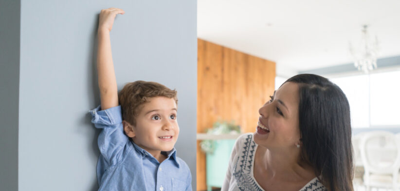 Mother measuring her son at home