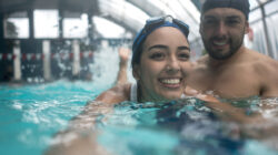 Young woman taking swimming lessons with a teacher