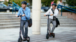 Businessmen riding electric scooter