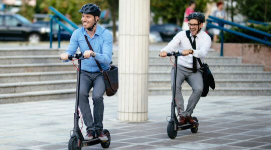 Businessmen riding electric scooter