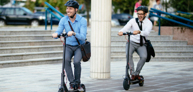 Businessmen riding electric scooter