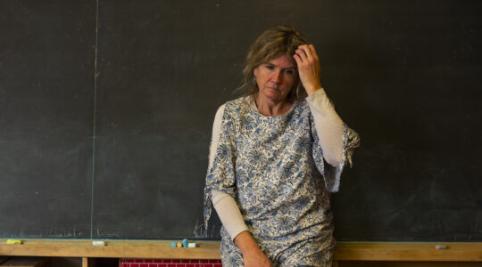 A stressed or depressed mature teacher in a classroom.
