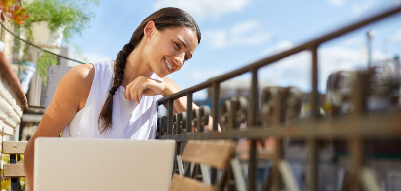 Working from home with a laptop at the balcony.