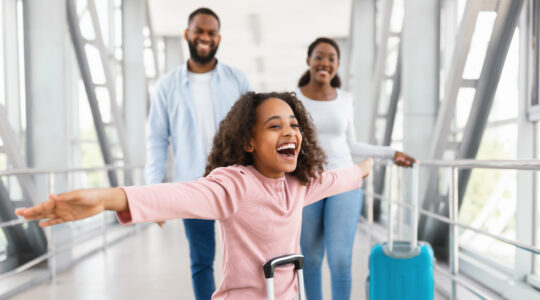 Happy family traveling with kid, standing in airport