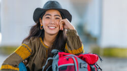 Portrait of cheerful female traveller by sea