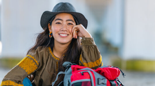 Portrait of cheerful female traveller by sea