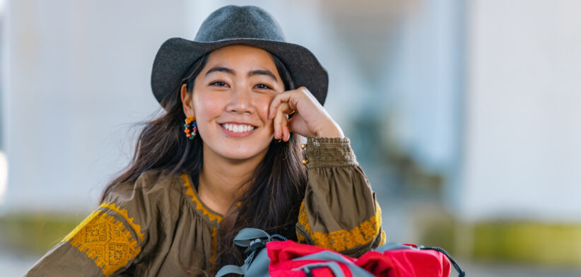 Portrait of cheerful female traveller by sea