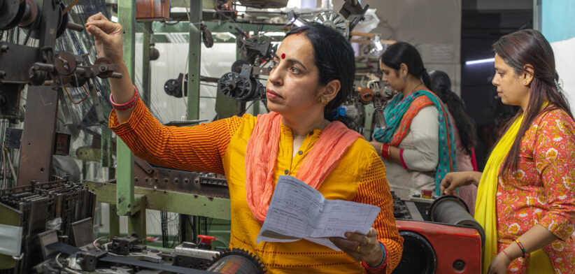 Woman inspecting equipment and workers manufacturing in textile factory