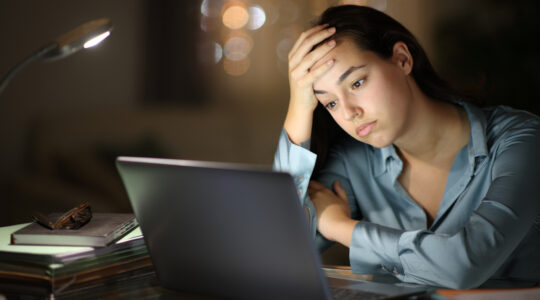 Worried tele worker checking laptop in the night