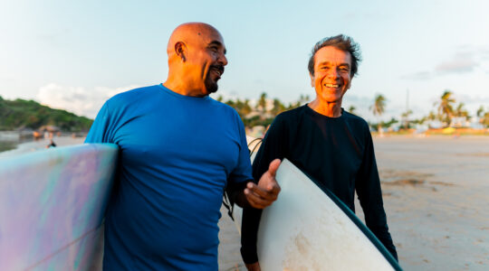 Senior surfer friends talking on the beach