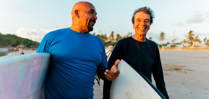 Senior surfer friends talking on the beach