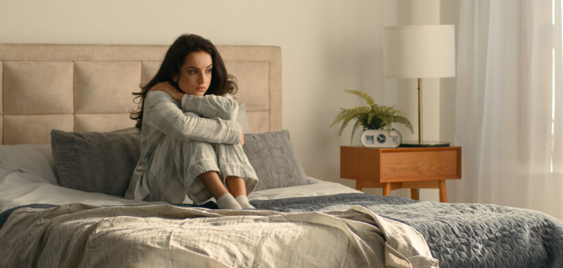 Woman hugging herself bed bedroom girl female hotel looking window rest relax calmness tranquility accommodation insurance wake up weekend cozy morning wellbeing daydream peaceful apartment domestic