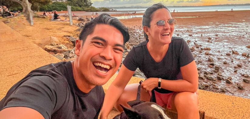 Couple Enjoying Sunset at Beach with Pet Dog