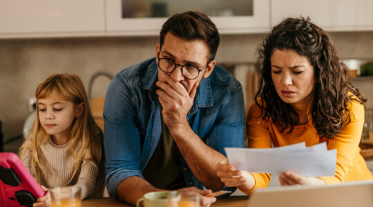 Worried family reading bad news on bills at home
