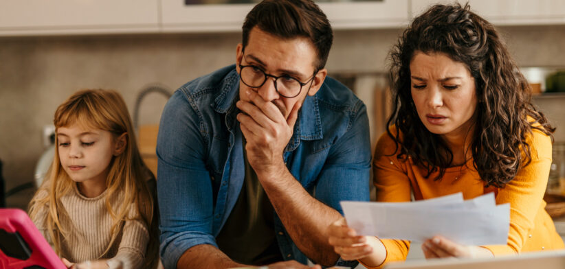 Worried family reading bad news on bills at home