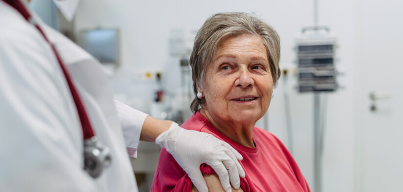 Elderly patient being vaccinated by doctor.