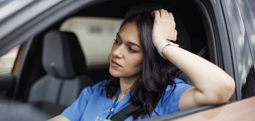 Tired female nurse sitting in the car after a long shift