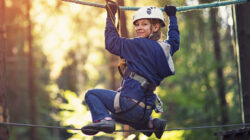 Little girl walking on line in ropes course adventure park