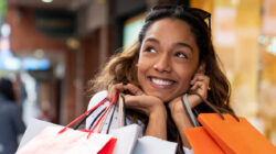 Excited shopping woman looking very happy holding bags