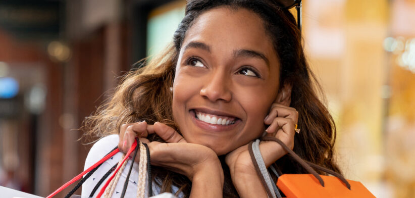 Excited shopping woman looking very happy holding bags