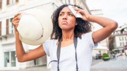 Black woman suffering and sweating for hot weather