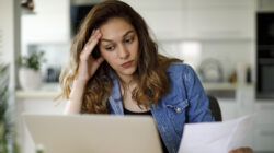 Worried young woman working at home