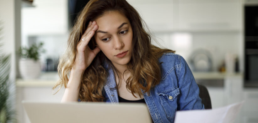 Worried young woman working at home