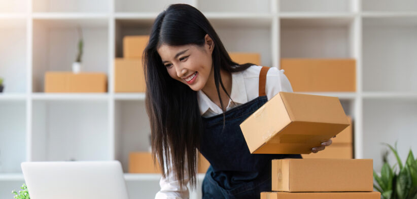 Startup SME small business entrepreneur of freelance Asian woman using laptop and box to receive and review orders online to prepare to pack sell to customers, online sme business ideas
