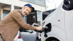 Happy man charging his hybrid truck