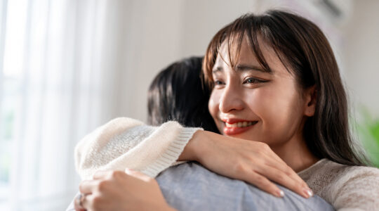 Asian young beautiful couple hugging each other in living room at home. Attractive romantic new marriage man and woman spending leisure time celebrate anniversary and valentine’s day together in house