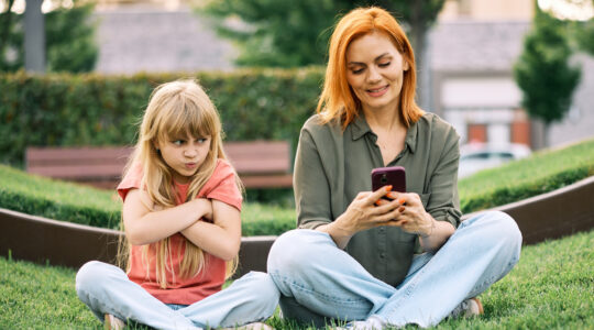 Redheaded Mother Ignoring Upset Blonde Daughter Outdoors