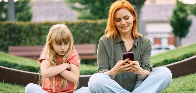 Redheaded Mother Ignoring Upset Blonde Daughter Outdoors