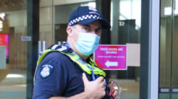 Victoria police officer wearing protective face mask at Covid-19 vaccination hub at Melbourne Convention Centre during lockdown in Victoria, Australia