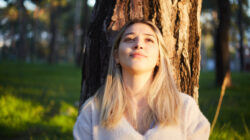 young girl dreaming while resting under the tree